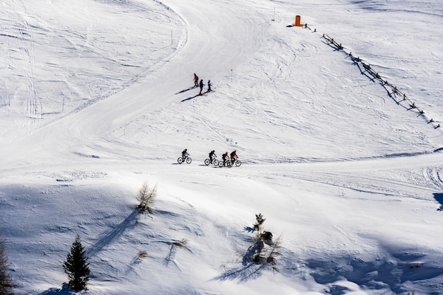 Piękny widok na ludzi jeżdżących na rowerze i na nartach przez zaśnieżone góry w Południowym Tyrolu, Dolomitach we Włoszech