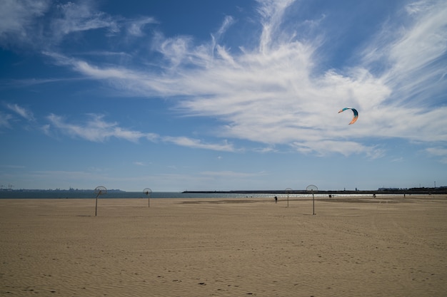 Piękny widok na piaszczystą plażę z zachmurzonym błękitnym niebem