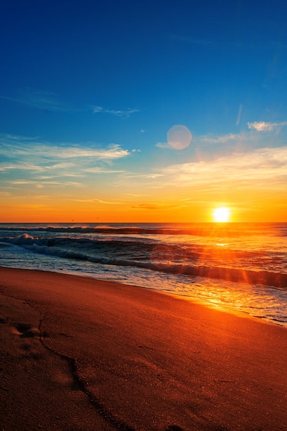Piękny wschód słońca na plaży pod błękitnym niebem