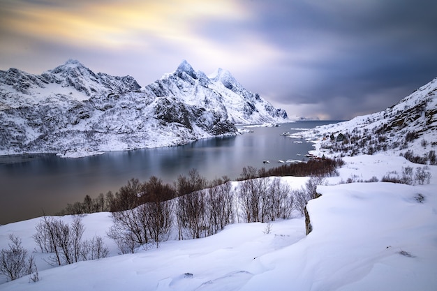 Piękny zimowy krajobraz ze śnieżnymi górami i lodowatą wodą