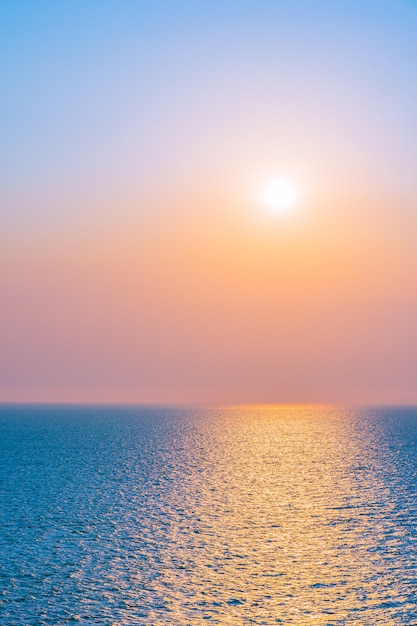 Bezpłatne zdjęcie piękny zmierzch lub wschód słońca wokoło dennej ocean zatoki z chmurą na niebie