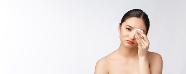 Pielęgnacja skóry kobieta usuwająca makijaż twarzy za pomocą wacika koncepcja pielęgnacji skóry Zbliżenie twarzy pięknego modelu rasy mieszanej z idealną skórą
