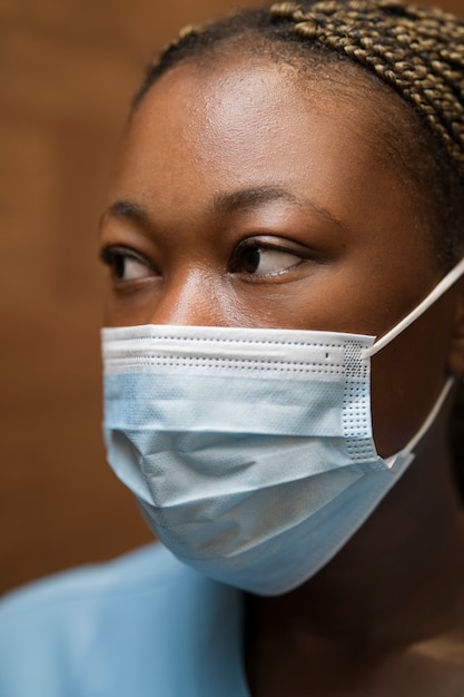 Bezpłatne zdjęcie pielęgniarka nosząca peelingi i maskę medyczną w klinice