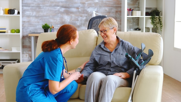 Pielęgniarka rozmawia ze starszą kobietą z chorobą Alzheimera w domu opieki