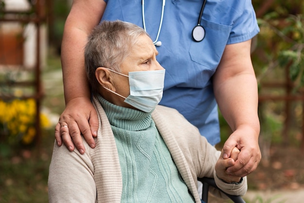 Bezpłatne zdjęcie pielęgniarka trzymając rękę starszej kobiety
