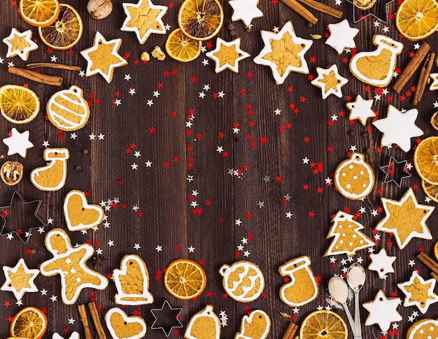Bezpłatne zdjęcie piernikowe ciasteczka świąteczne nowy rok pomarańcze cynamon na drewnianym stole z copyspace