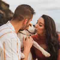 Bezpłatne zdjęcie pies całowany przez parę