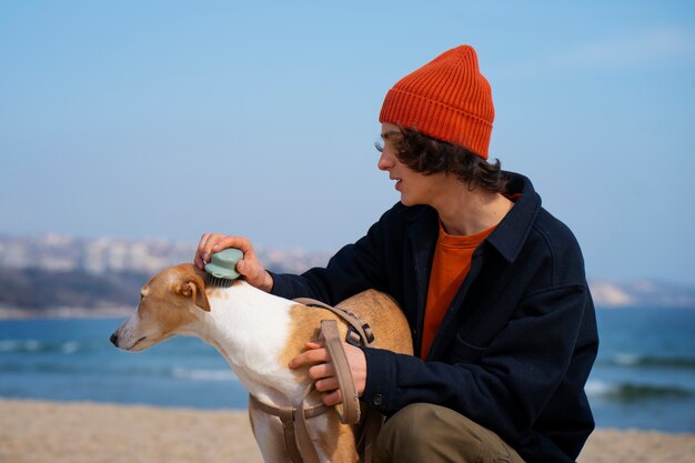 Bezpłatne zdjęcie pies chartów z męskim właścicielem na plaży
