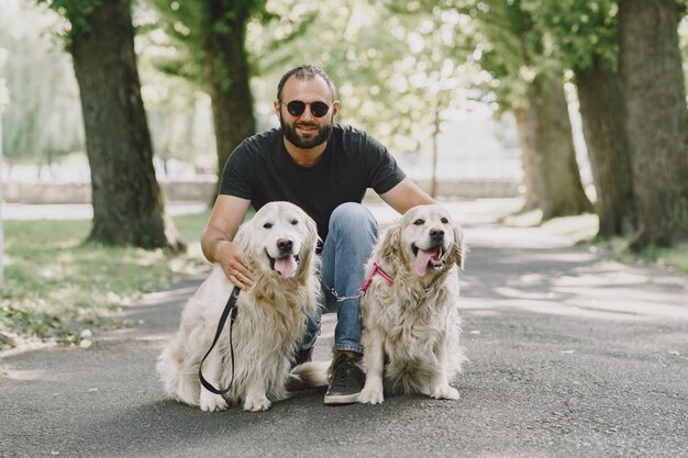 Pies przewodnik pomagający niewidomemu w mieście. Przystojny ślepy facet odpoczywa z golden retriever w mieście.