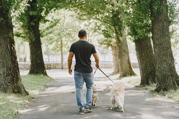 Pies przewodnik pomagający niewidomemu w mieście. Przystojny ślepy facet odpoczywa z golden retriever w mieście.