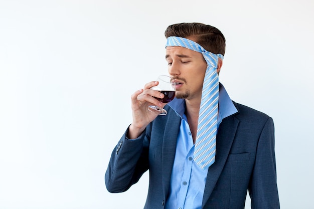 Pijany biznesmen z bólem głowy do picia czerwonego wina