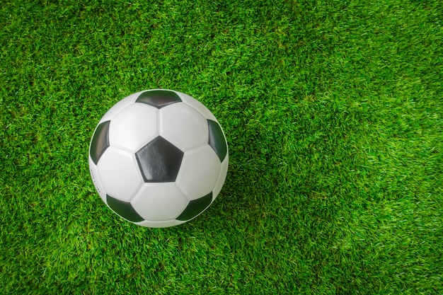 Piłka nożna na zielonej trawie.