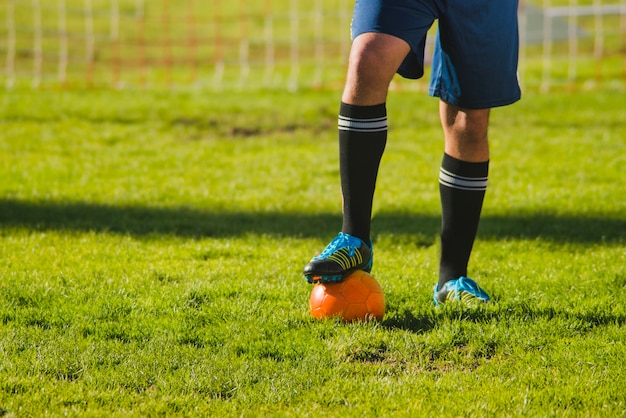 Bezpłatne zdjęcie piłkarz stawia stopę w piłkę