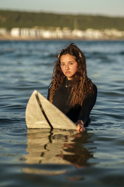 Pionowe, płytkie ujęcie młodego europejskiego surfera w wodzie