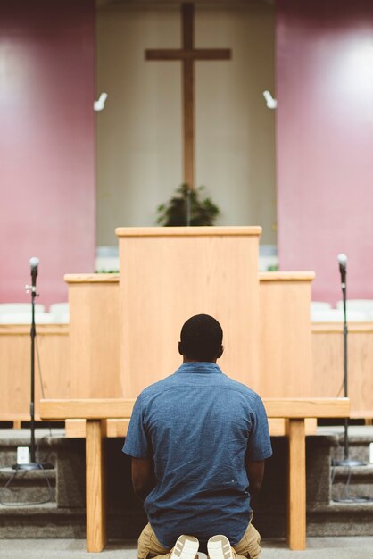 Pionowe ujęcie Afroamerykanina modlącego się w kościele