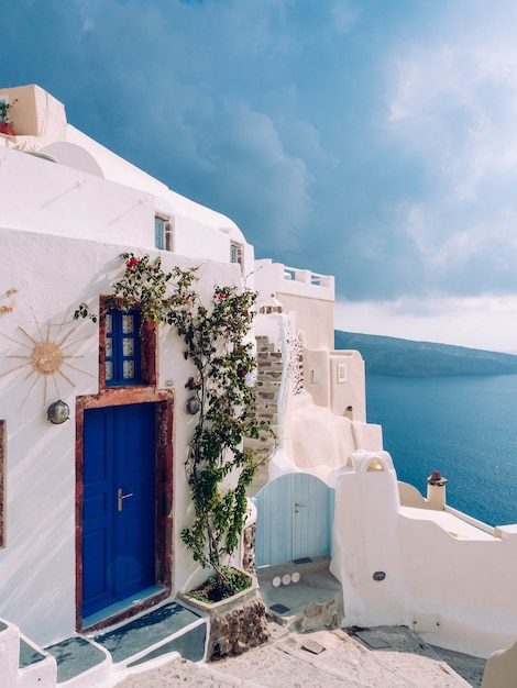 Pionowe ujęcie budynku z niebieskimi drzwiami na Santorini w Grecji