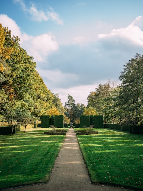 Pionowe ujęcie Hoetger Park pokryte zielenią pod zachmurzonym niebem w słońcu w Dortmundzie