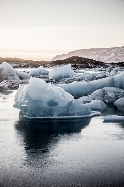 Pionowe ujęcie kilku kawałków lodu w lagunie lodowcowej Jokulsarlon na Islandii