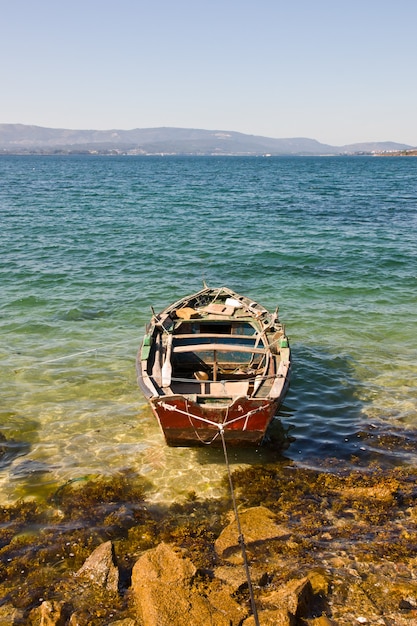 Pionowe ujęcie małej drewnianej łodzi zaparkowanej w pobliżu brzegu morza