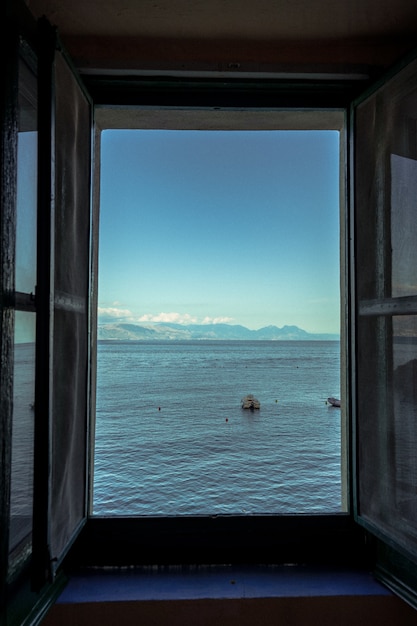 Pionowe ujęcie otwartego okna z widokiem na piękne morze