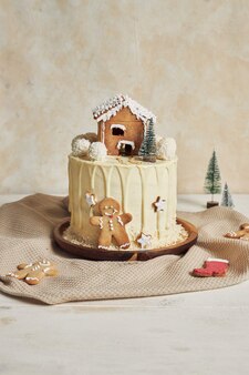 Pionowe ujęcie pysznego świątecznego ciasta z piernikowymi dekoracjami i kokosowymi kuleczkami migdałowymi