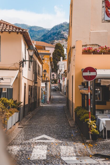 Pionowe ujęcie ścieżki w środku budynków w Funchal na Maderze w Portugalii.