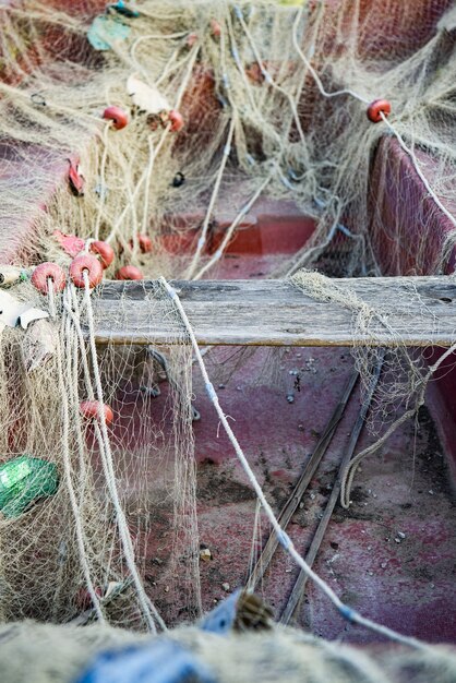 Pionowe ujęcie starej łodzi pokrytej siecią rybacką