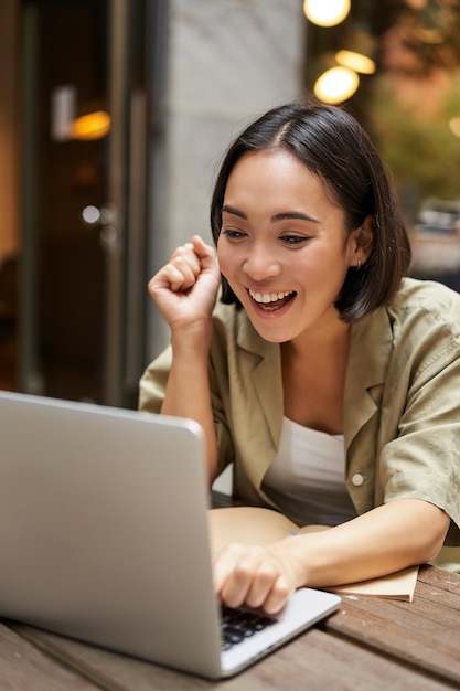 Pionowe ujęcie szczęśliwej dziewczyny rozmawiającej podczas rozmowy wideo patrzy na laptopa po spotkaniu online siedzącym w o