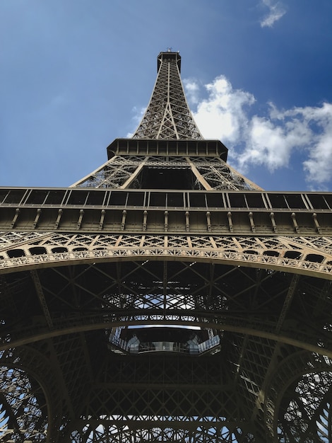 Pionowe ujęcie wieży Eiffla w Paryżu pod niskim kątem