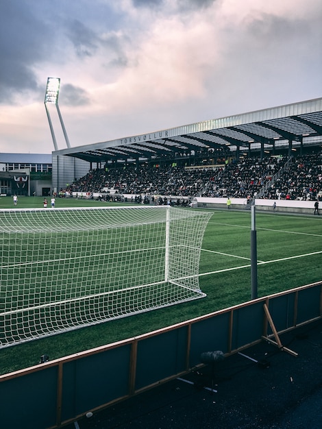 Pionowe ujęcie zatłoczonego stadionu piłkarskiego w pochmurne niebo