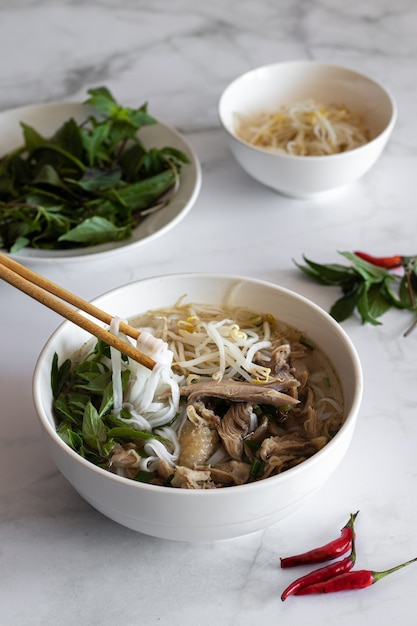 Bezpłatne zdjęcie pionowe ujęcie zupy pho bo z patykami, wietnamskie jedzenie, wietnamska kuchnia