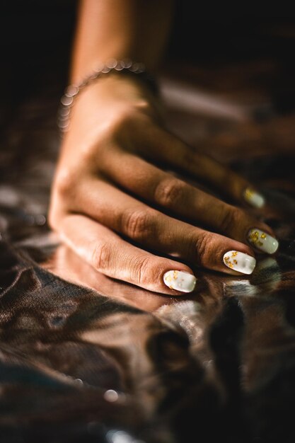 Pionowe zbliżenie kobiecej dłoni z białym manicure