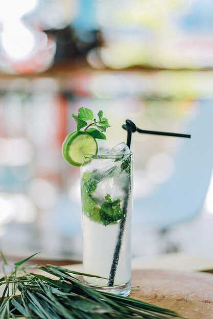 Pionowe zbliżenie zimnego koktajlu mojito na stole pod światłami