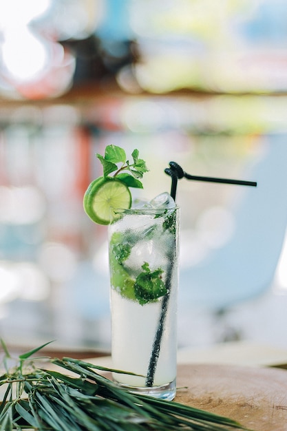 Pionowe zbliżenie zimnego koktajlu mojito na stole pod światłami