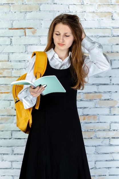 Pionowe zdjęcie młodej studentki czytającej notatki Zdjęcie wysokiej jakości