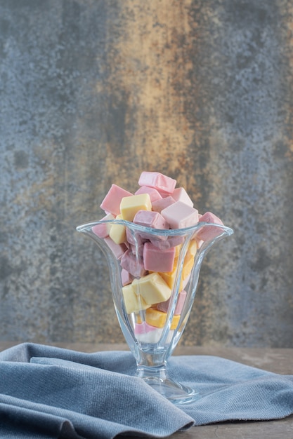 Bezpłatne zdjęcie pionowe zdjęcie świeżych słodkich cukierków w szklanym szkle do lodów.