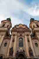 Bezpłatne zdjęcie pionowo niski kąt strzelał st. nicholas kościół pod chmurnym niebem w praga, republika czech