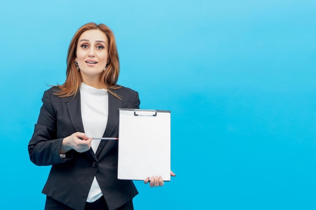 Pionowy portret młodej bizneswoman wskazuje jej długopis na jej notatnik