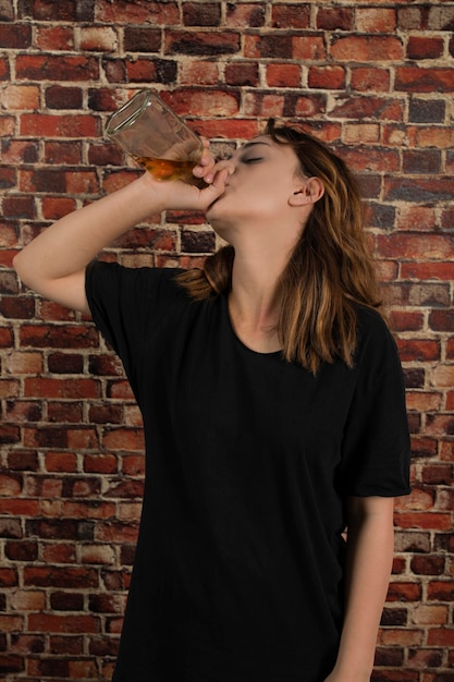 Bezpłatne zdjęcie pionowy portret przygnębionej dziewczyny picia alkoholu. zdjęcie wysokiej jakości