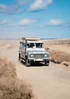 Bezpłatne zdjęcie pionowy samochód terenowy poruszający się po pustynnej drodze