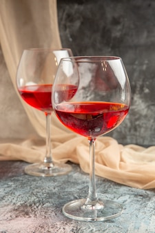 Pionowy widok dwóch szklanek pysznego wytrawnego czerwonego wina i ręcznika na lodowym tle