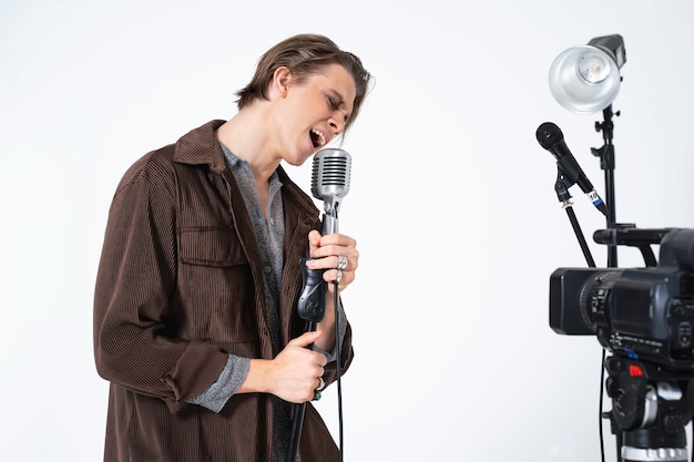 Bezpłatne zdjęcie piosenkarka o średnim ujęciach z mikrofonem