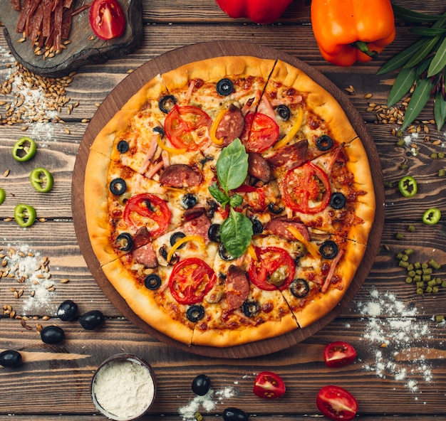 pizza pizza wypełniona pomidorami, salami i oliwkami