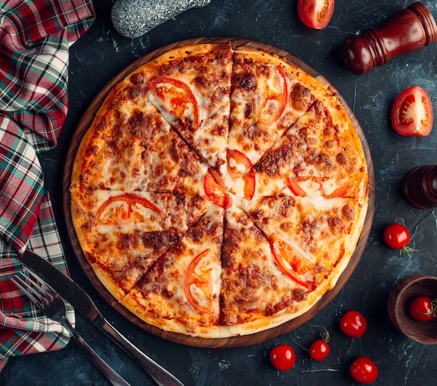 Pizza z farszem mięsnym i plasterkami pomidorów.