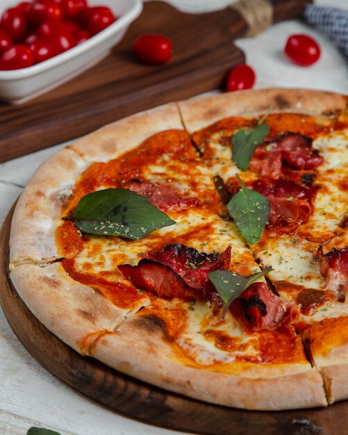 pizza z kiełbasą zwieńczona liściem laurowym