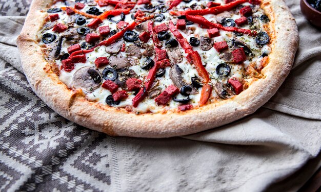 Pizza z mieszanymi składnikami i posiekaną czerwoną papryką