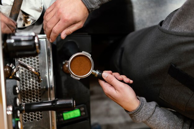 Płaski leżał męski barista trzymając kubek profesjonalnego ekspresu do kawy