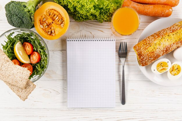 Płaski układ notebooka z posiłkami i warzywami