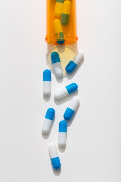 Bezpłatne zdjęcie płaski układ tabletek wychodzących z plastikowego pojemnika