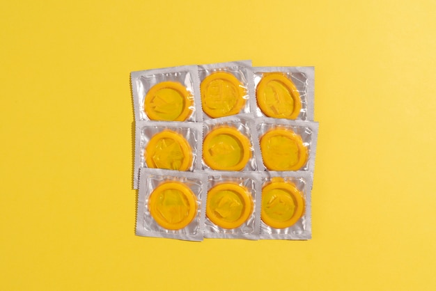 Bezpłatne zdjęcie płaski układ żółtych prezerwatyw